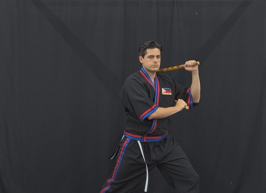 Modern Arnis Mano-Mano instructor with rattan stick in striking stance