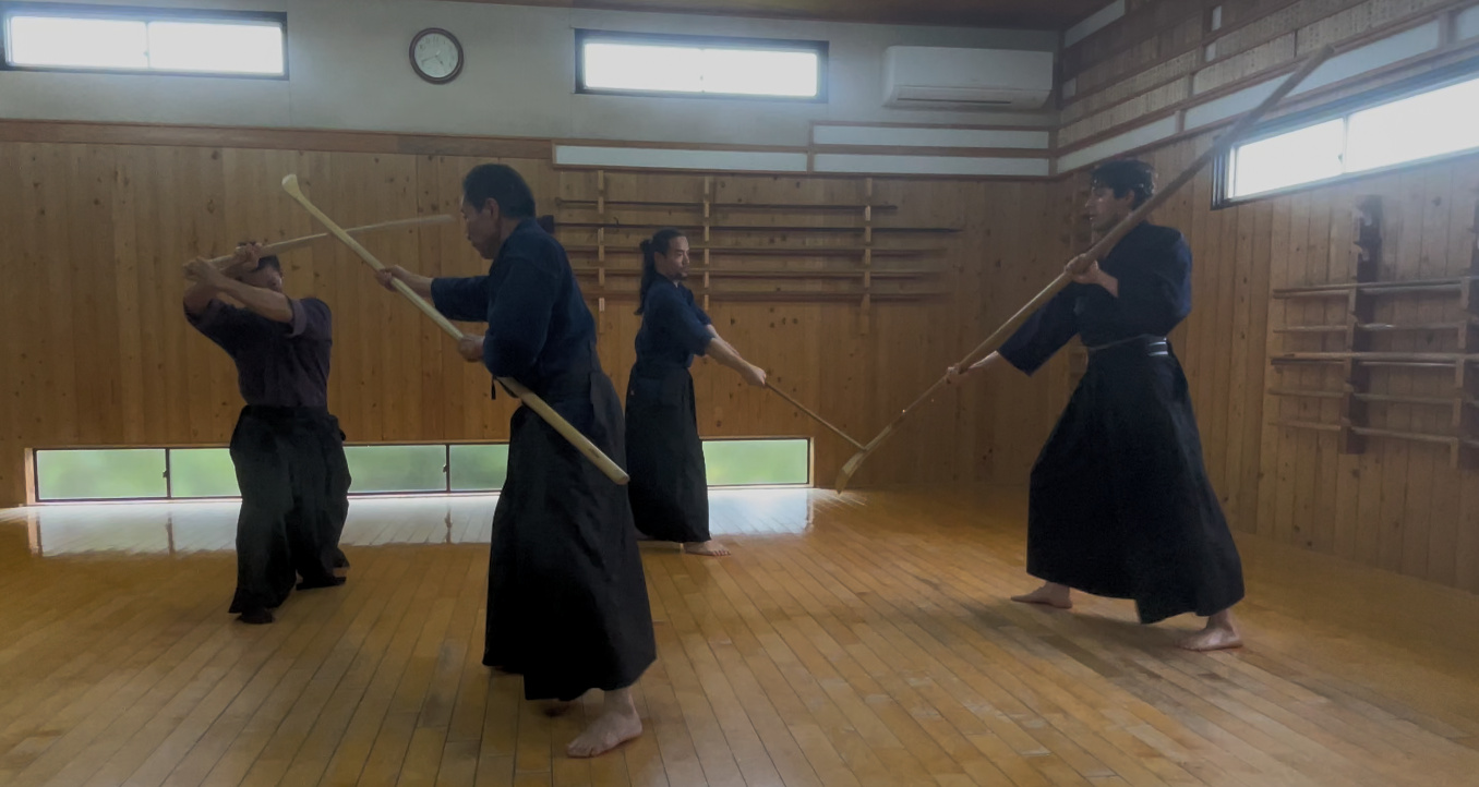 Katori Shinto-Ryu practitioners training with bo and bokken in a traditional dojo