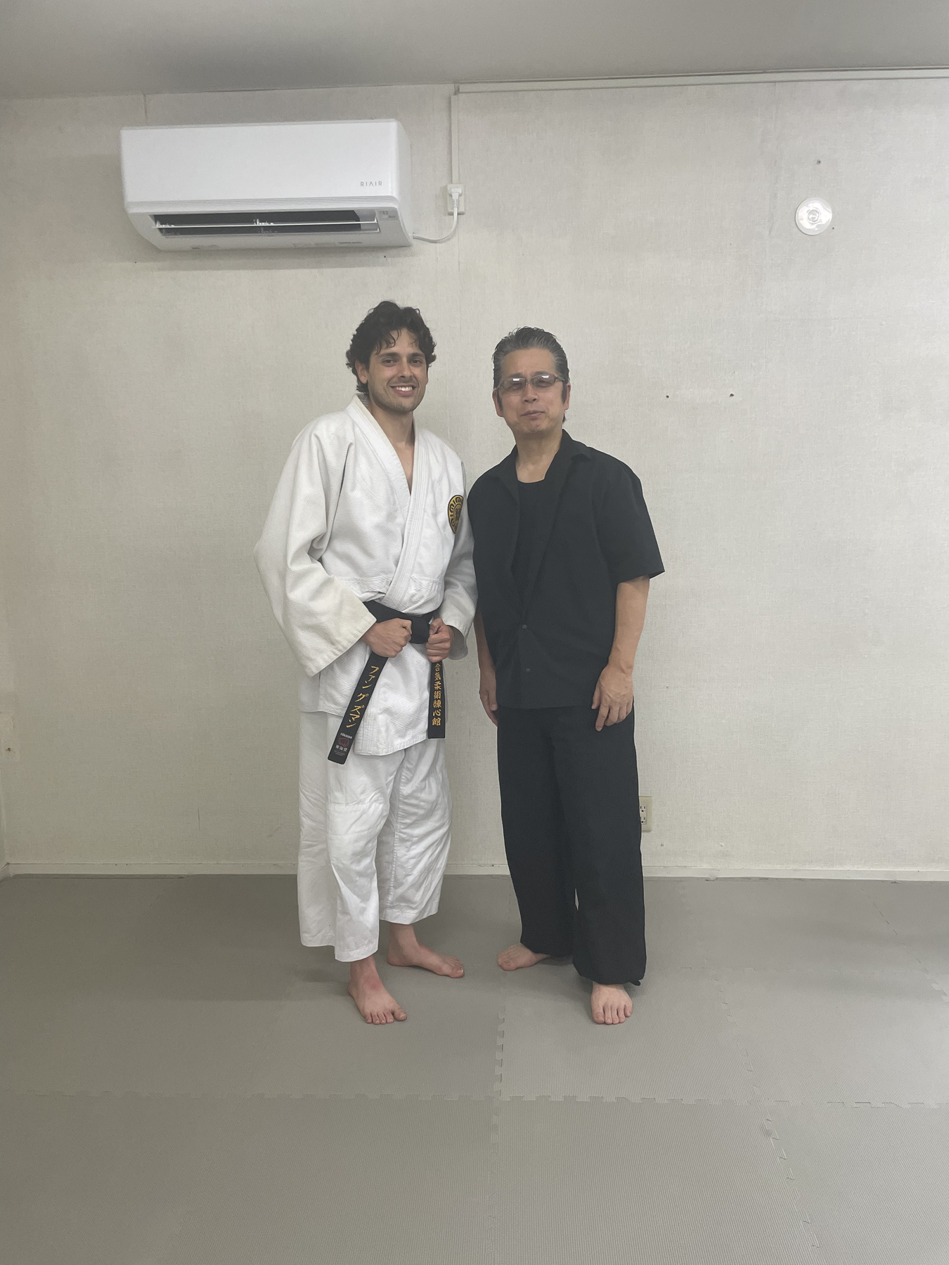Instructor with Renshinkan sensei in the dojo wearing traditional keikogi