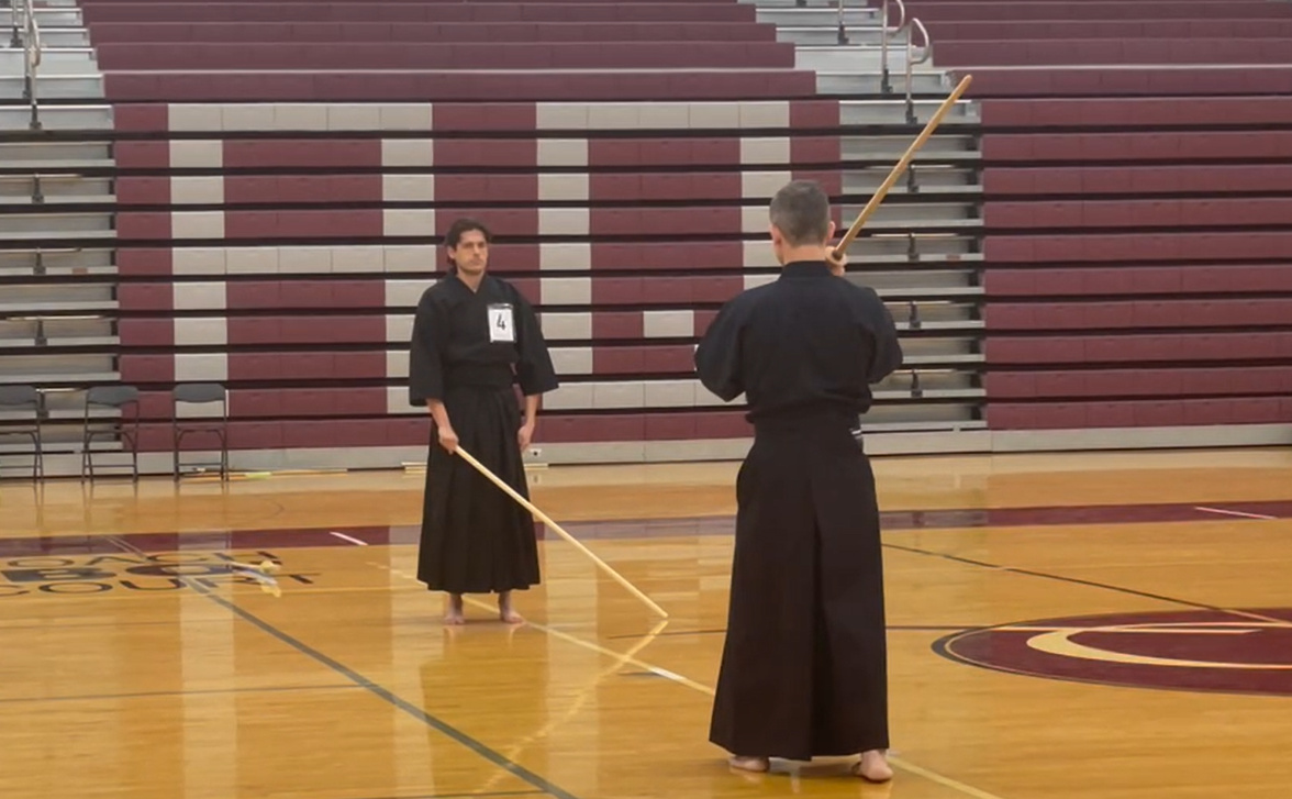Instructor practicing Seitei Jodo paired kata in keikogi and hakama