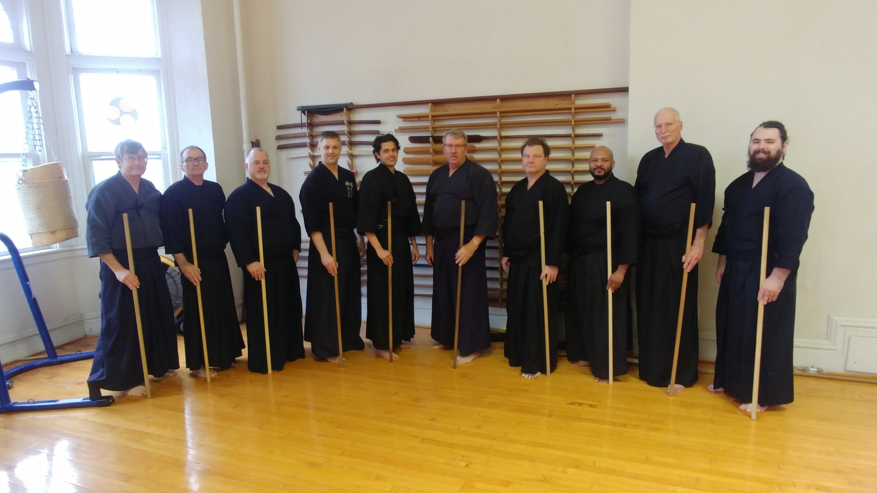 Group photo of Seitei Jodo practitioners with jo staffs in the dojo
